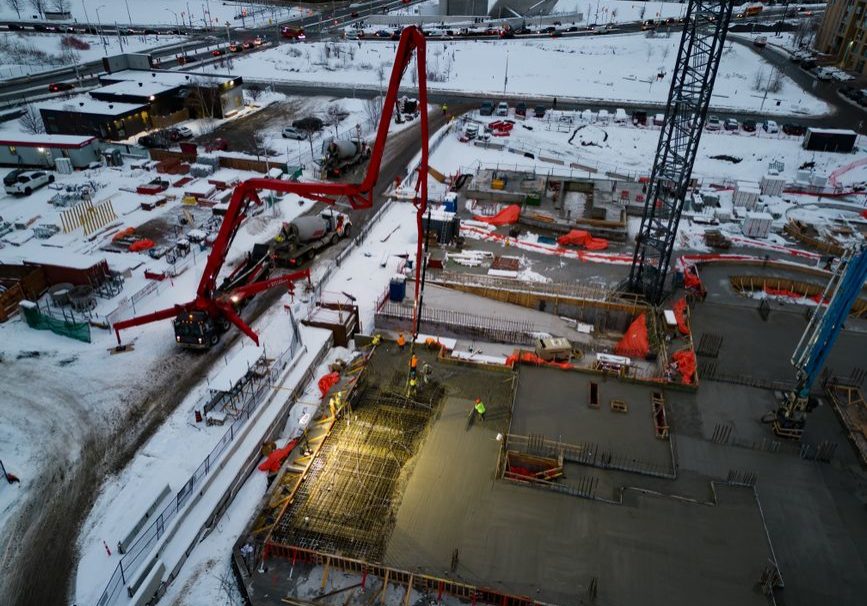 Drone shot of a snowy construction site with heavy machinery in Ottawa, Canada.