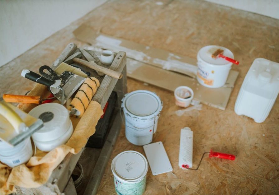 Overhead shot of tools and paint supplies for a home renovation project.