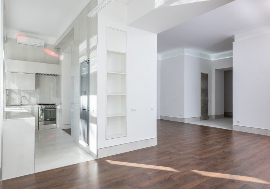 Spacious modern interior featuring an open kitchen and living area with elegant wooden flooring, ideal for contemporary homes.